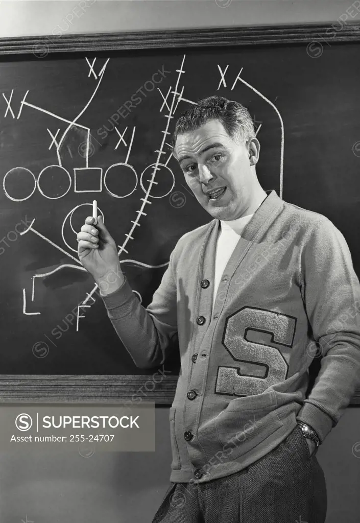 Vintage photograph. Picture of Football Coach in front of blackboard with plays.