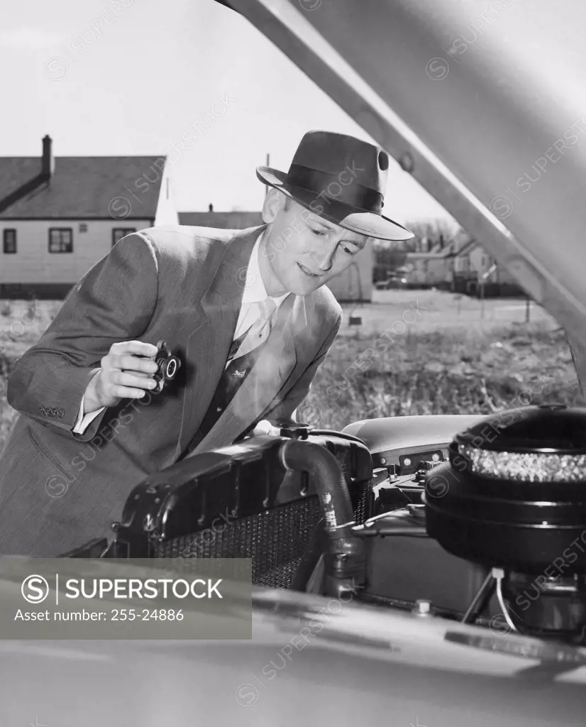 Mature man examining the engine of his car