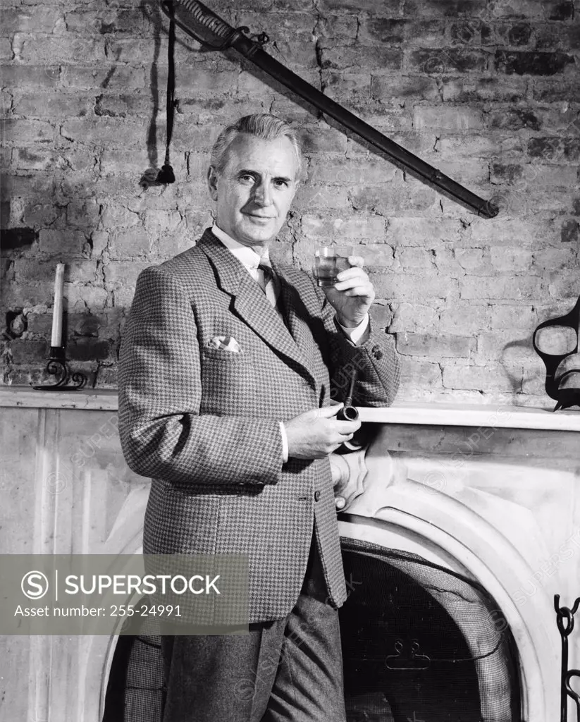 Portrait of a mature man holding a glass of wine and a pipe