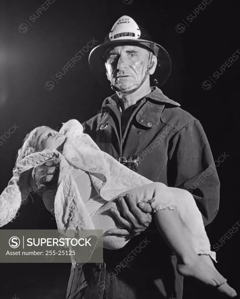Portrait of a fireman carrying an injured child