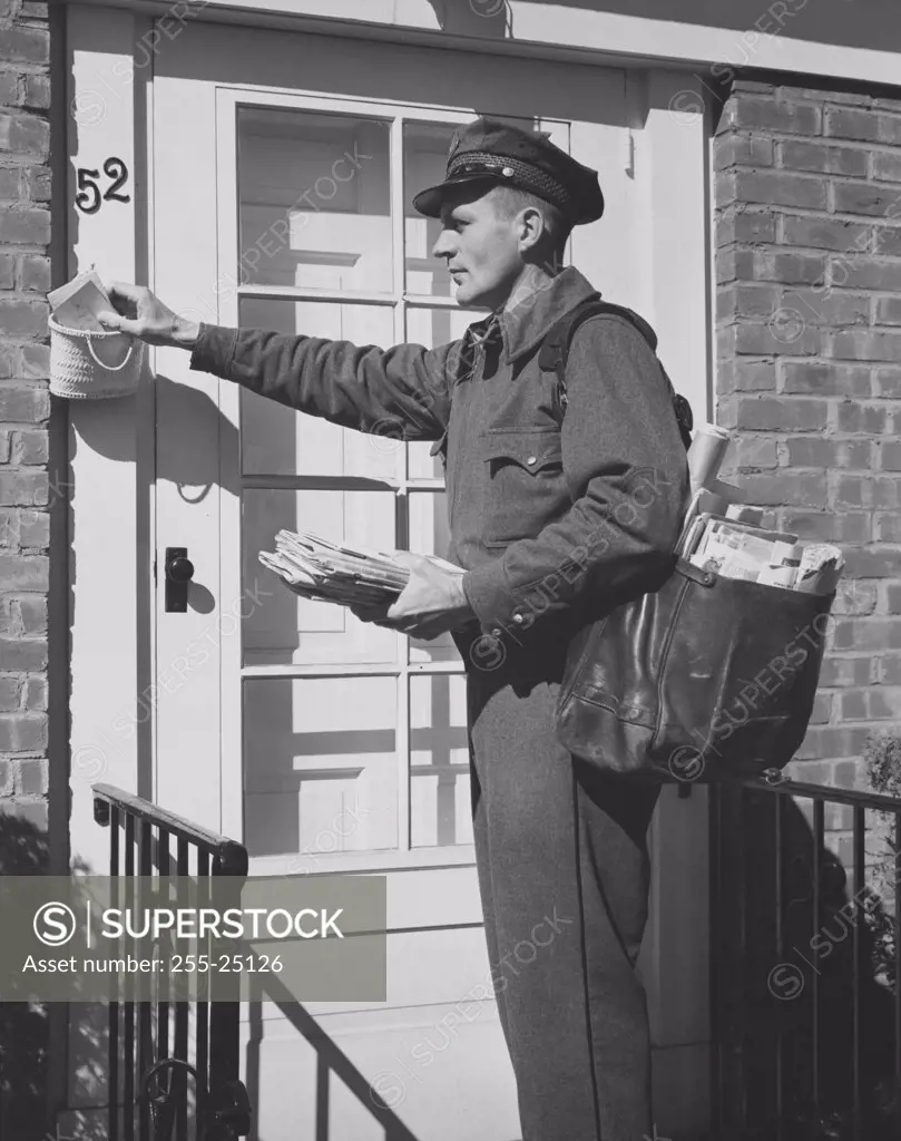 Side profile of a postman delivering mail