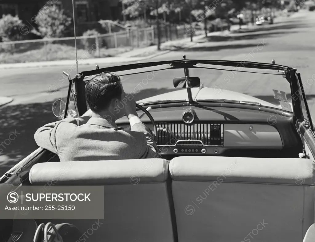 Vintage Photograph. Back of man sitting in front seat of Chevrolet Convertible