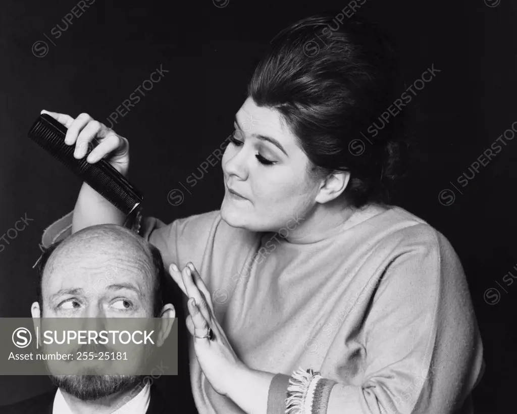 Close-up of a female hairdresser grooming a mid adult man