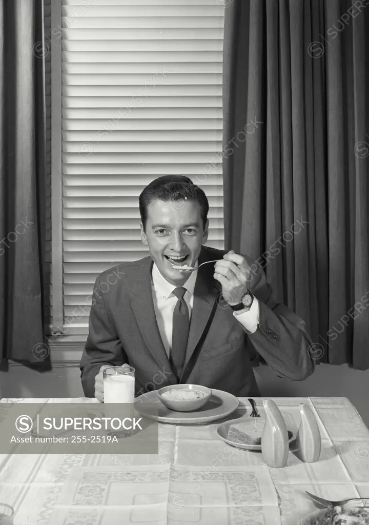 Vintage Photograph. Man at table eating oatmeal. Frame 1
