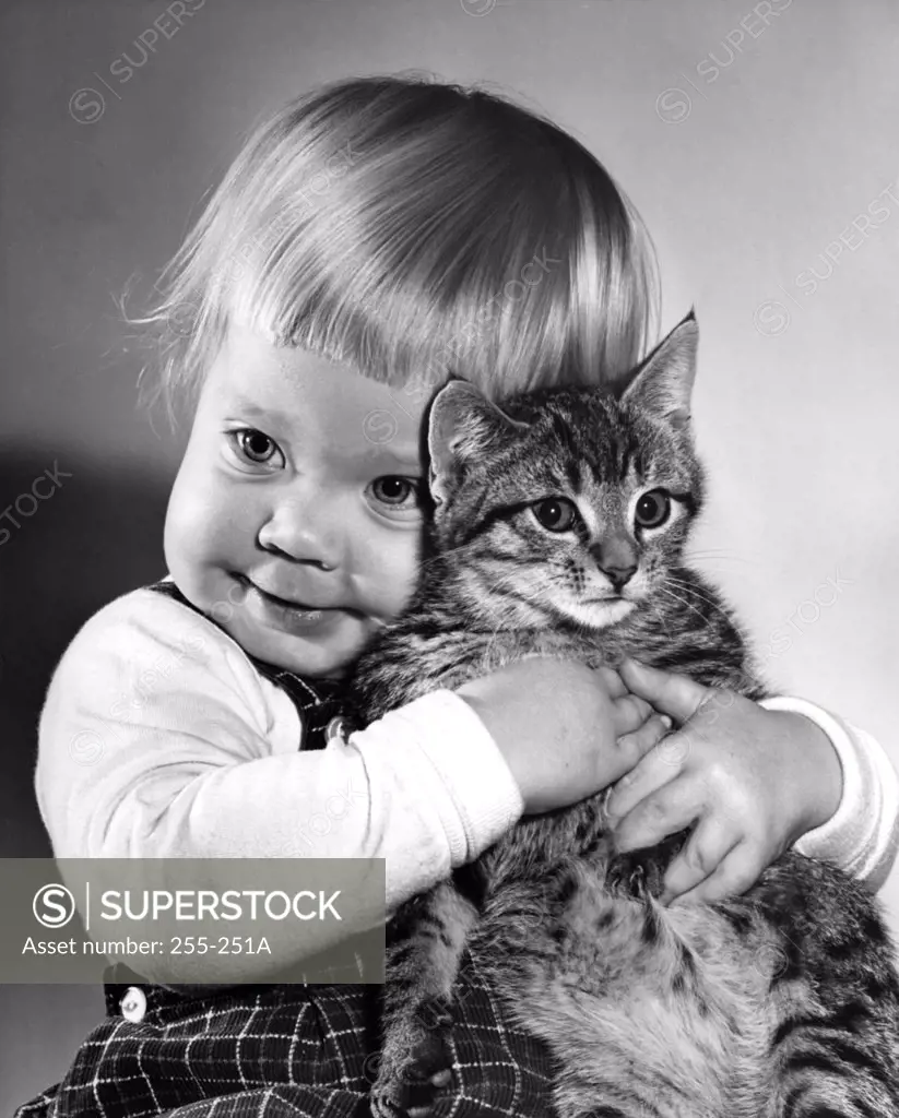 Portrait of baby girl hugging cat