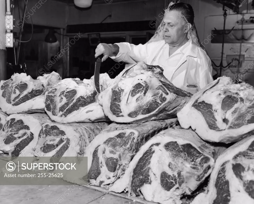 Butcher inspecting beef at a butcher's shop