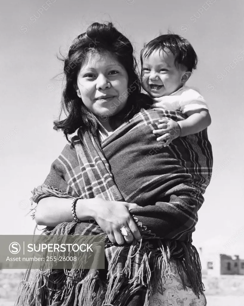 Hopi woman carrying her son