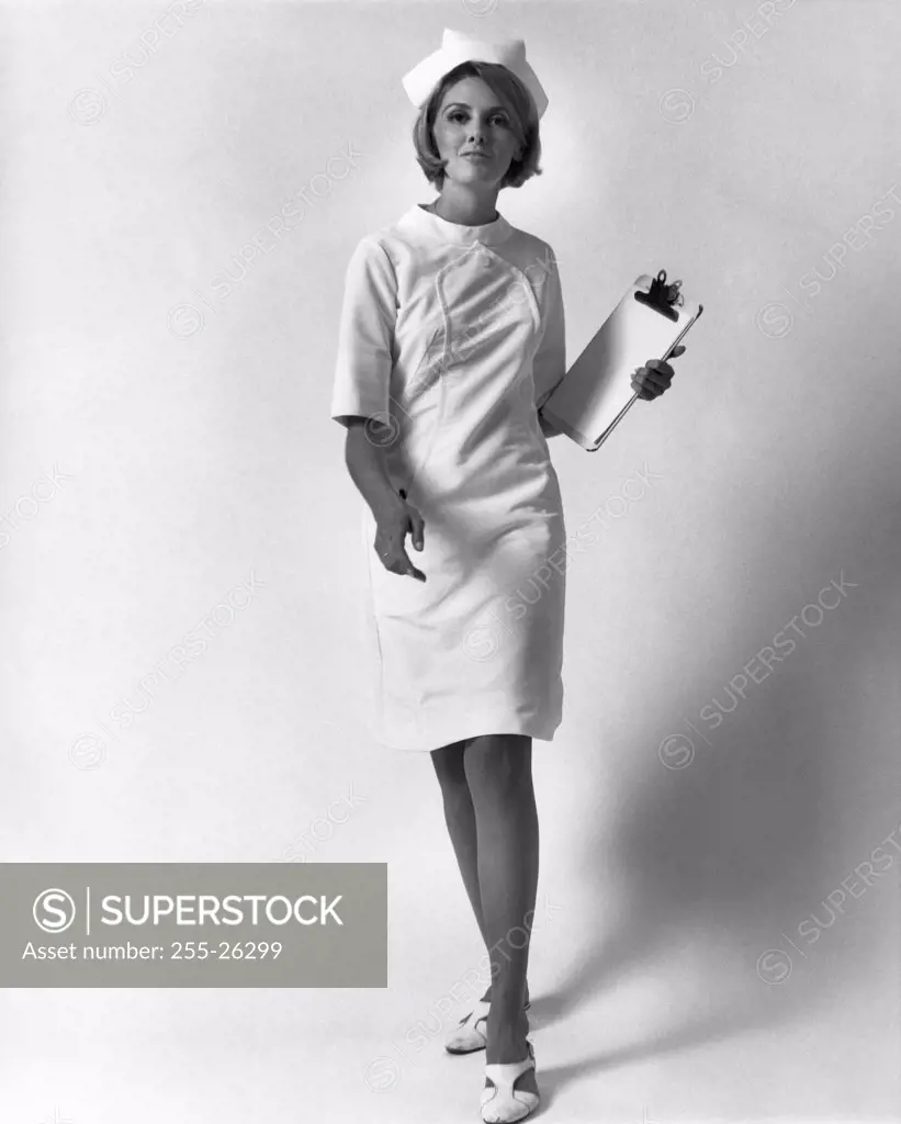 Portrait of a female nurse walking and holding a clipboard