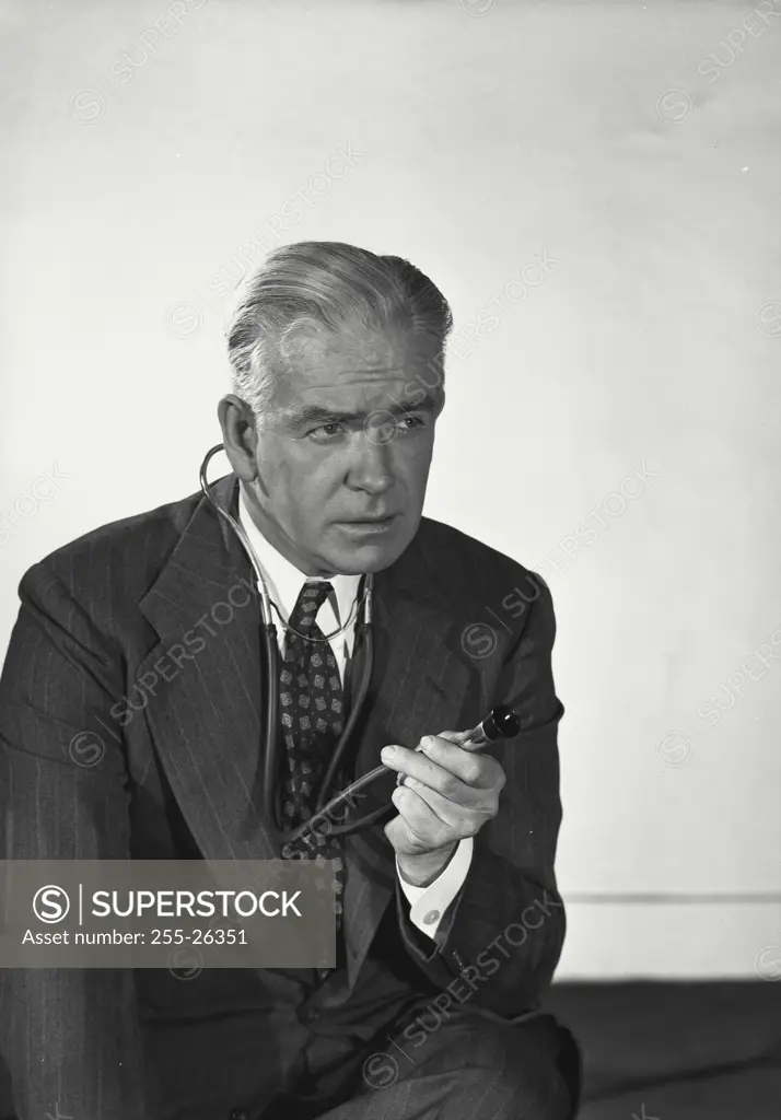 Vintage Photograph. Man in suit wearing stethoscope around neck