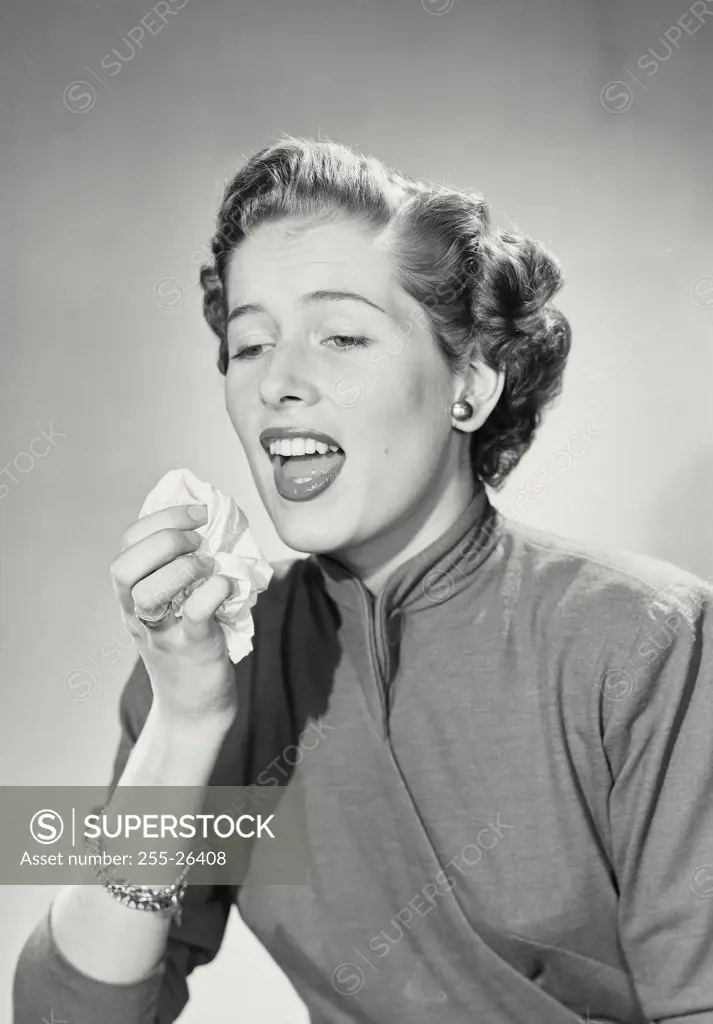 Vintage photograph. Woman in coat coughing into handkerchief.