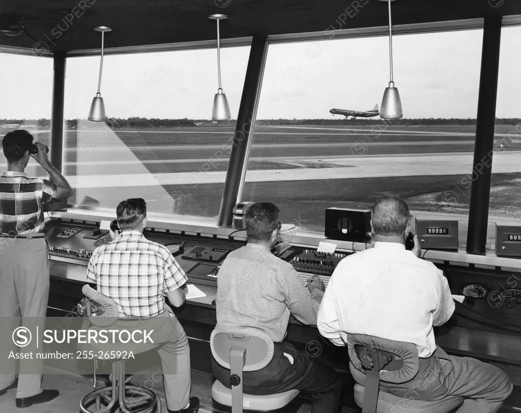 Rear view of four technicians working in an air traffic control tower, Sarasota-Bradenton International Airport, Sarasota, Florida, USA