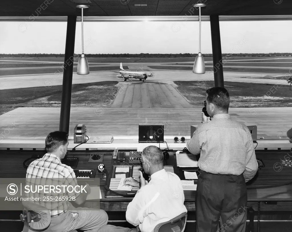 Rear view of three technicians working in an air traffic control tower, Sarasota-Bradenton International Airport, Sarasota, Florida, USA
