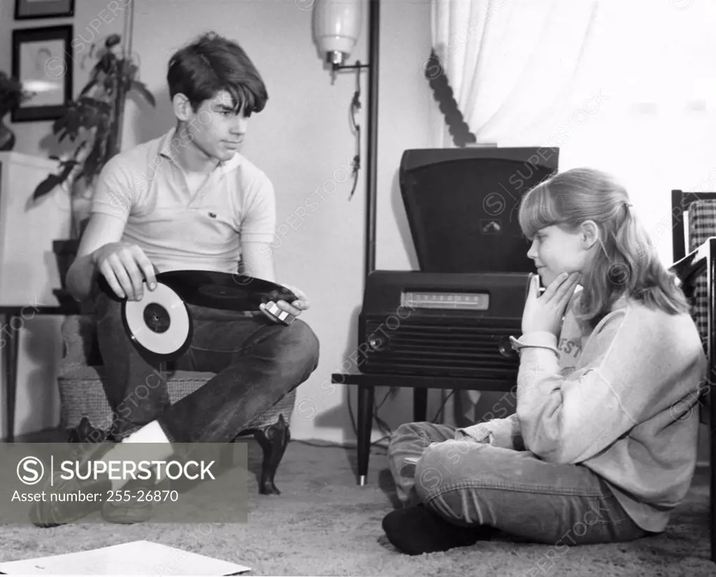Teenage couple sitting near a record player