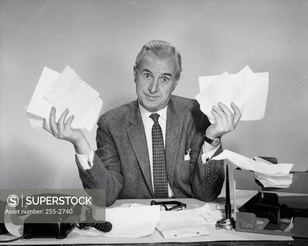 Businessman sitting at a desk and holding documents