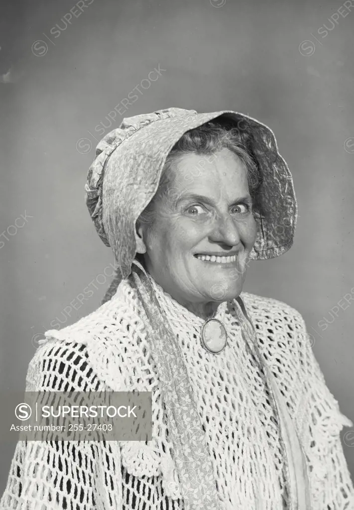 Woman in bonnet smiling with lowered eyebrows