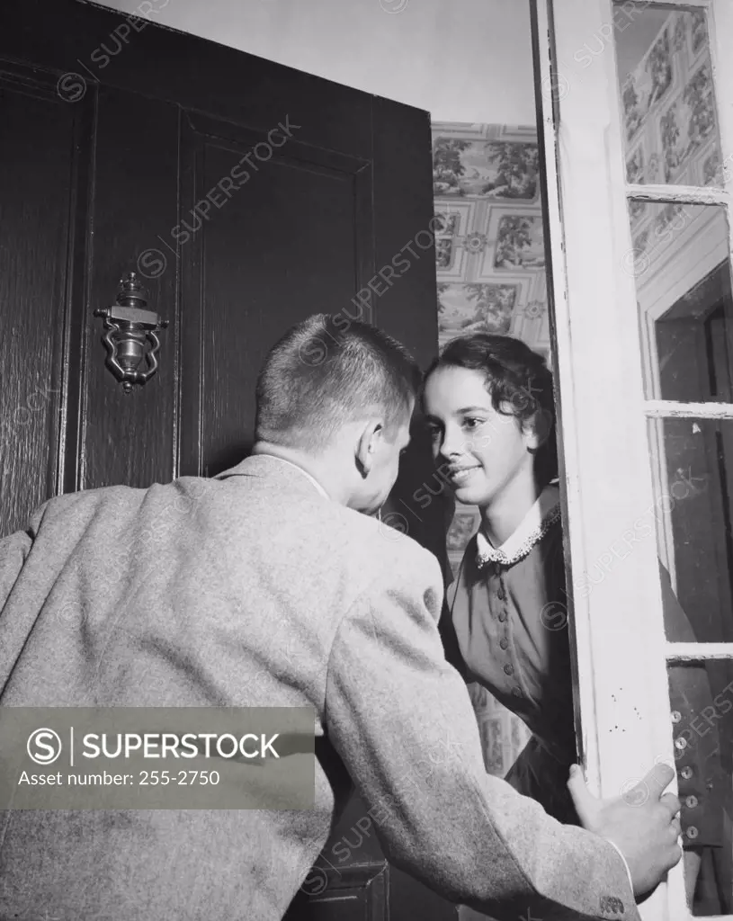 Young woman opening the front door for her date