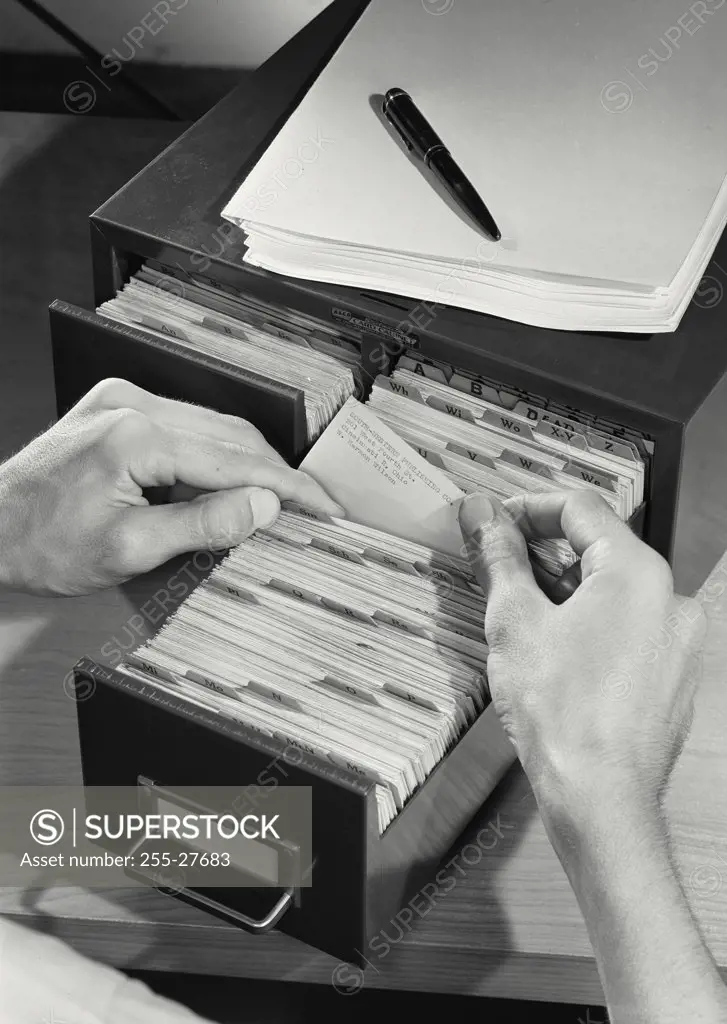 Vintage photograph. Close-up of a business person filing cards in drawer
