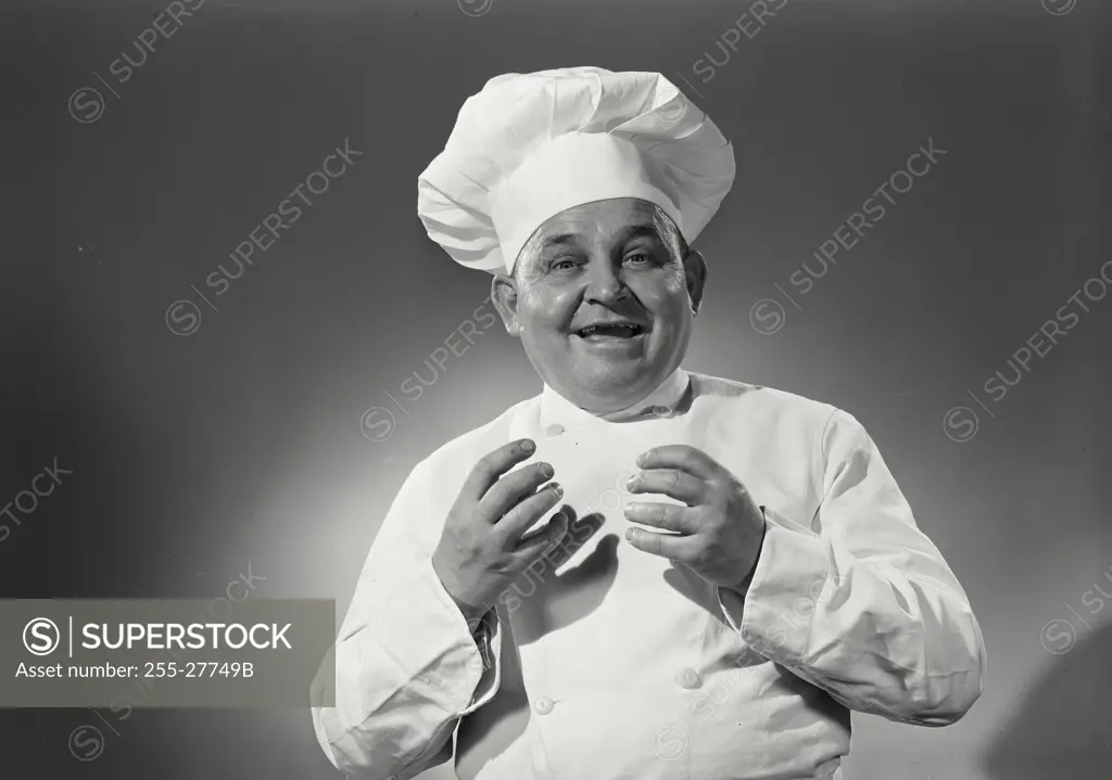 Vintage Photograph. Man in chefs uniform holding hands up