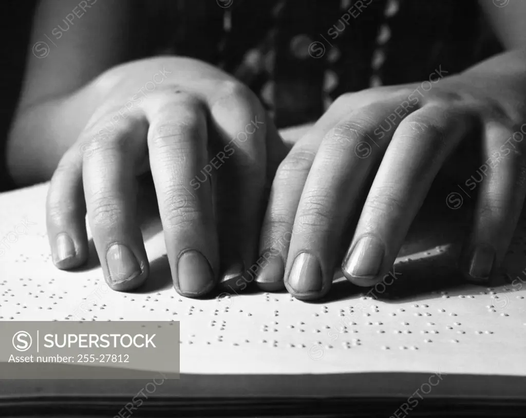 Close-up of woman's hands reading Braille