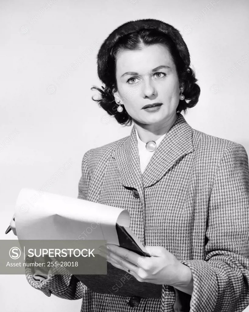 Close-up of a businesswoman holding a pen and a clipboard