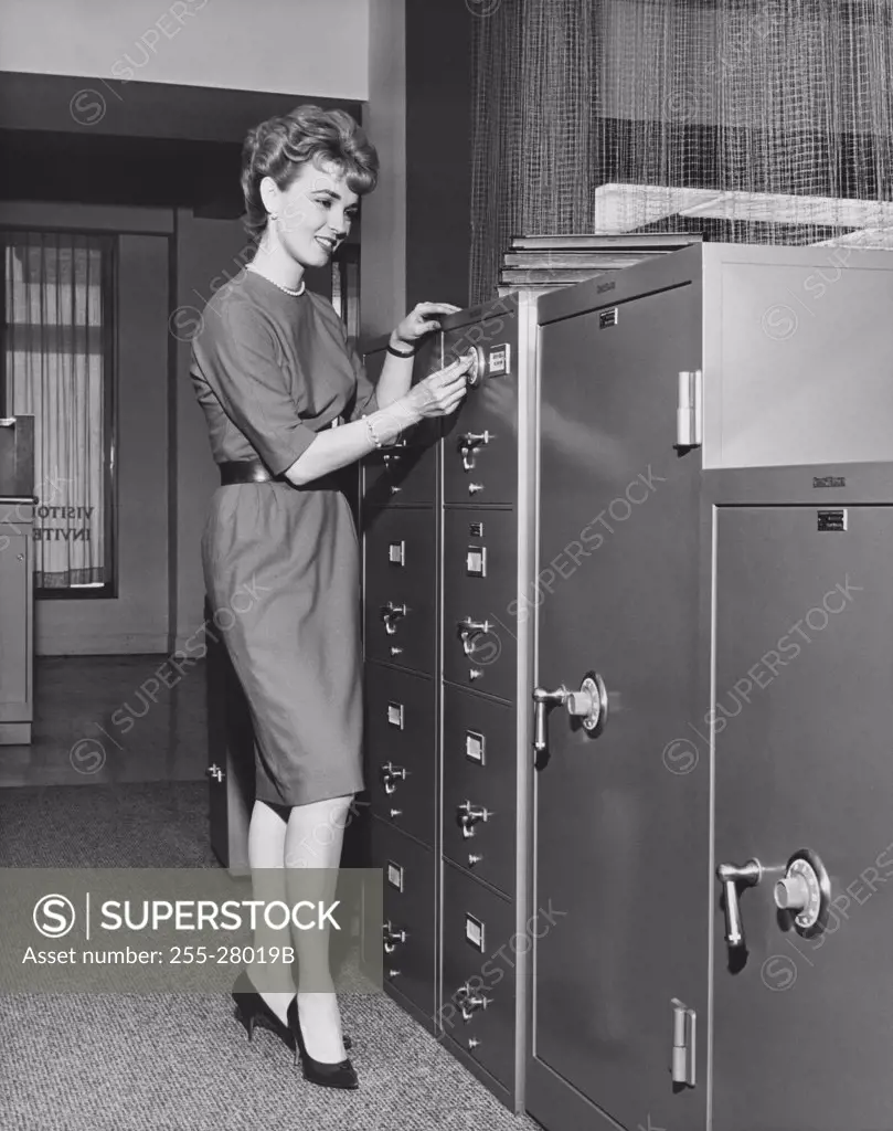 Businesswoman opening a combination lock