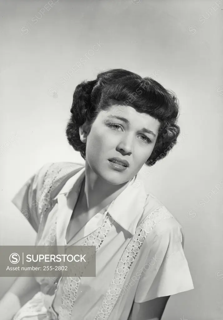 Vintage Photograph. Woman in waitress uniform with uncomfortable expression on face.
