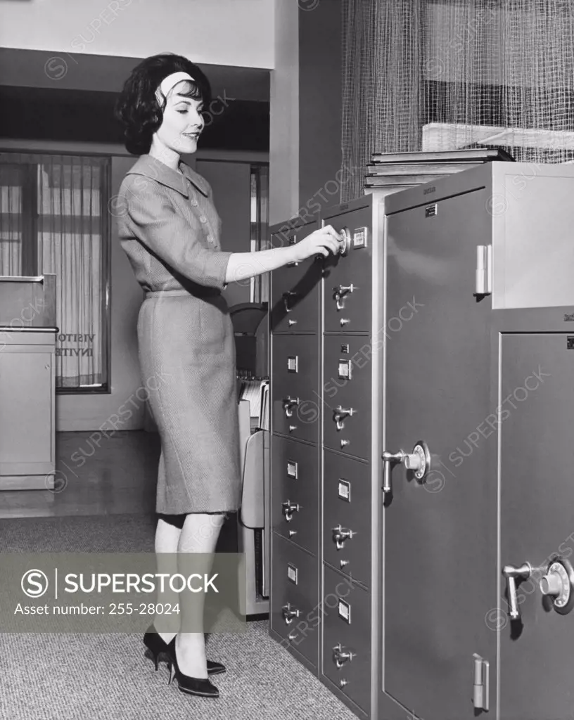 Businesswoman opening a filing cabinet