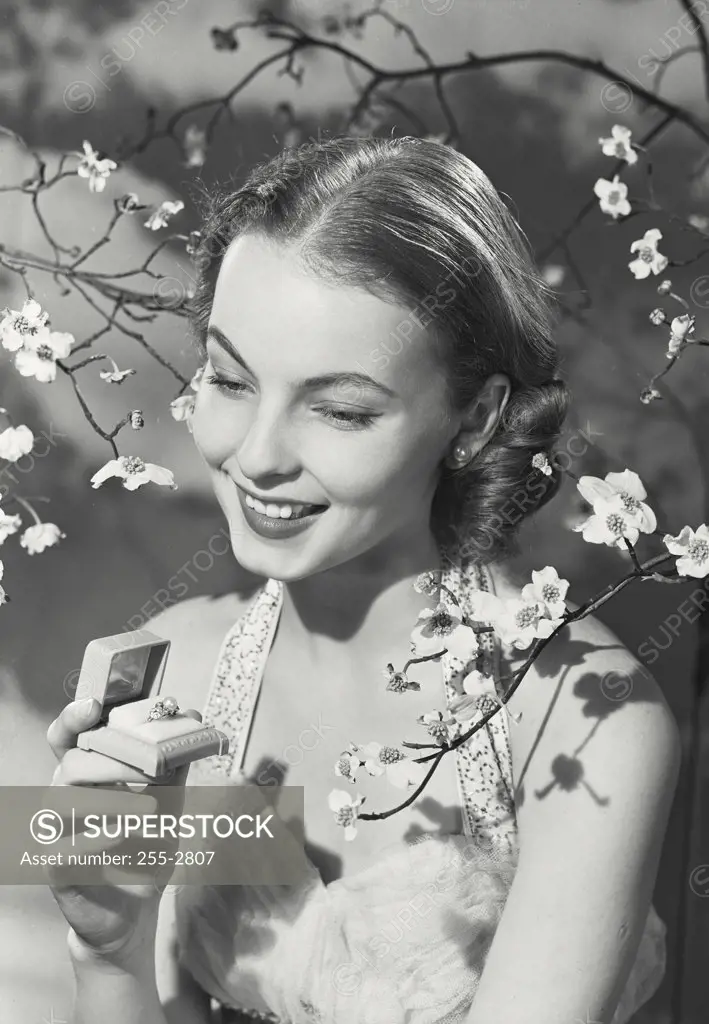 Vintage photograph. Portrait of woman in dress smiling in dogwood branches.