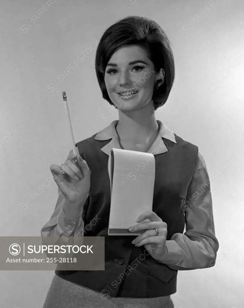 Studio portrait of secretary holding notepad