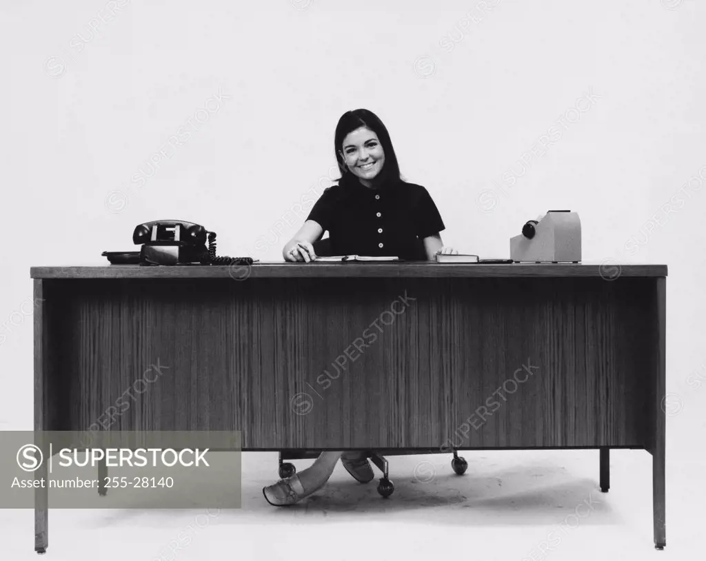 Businesswoman sitting at a desk and smiling in an office