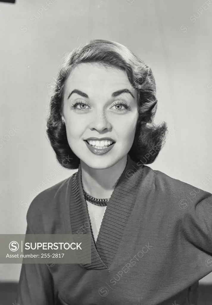 Vintage photograph. Close-up of a brunette woman with eyebrows raised and her hand in her hair