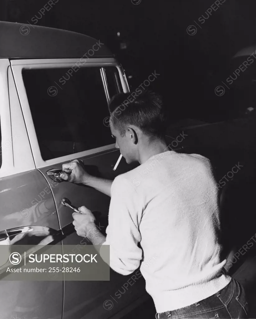Rear view of a thief stealing a car