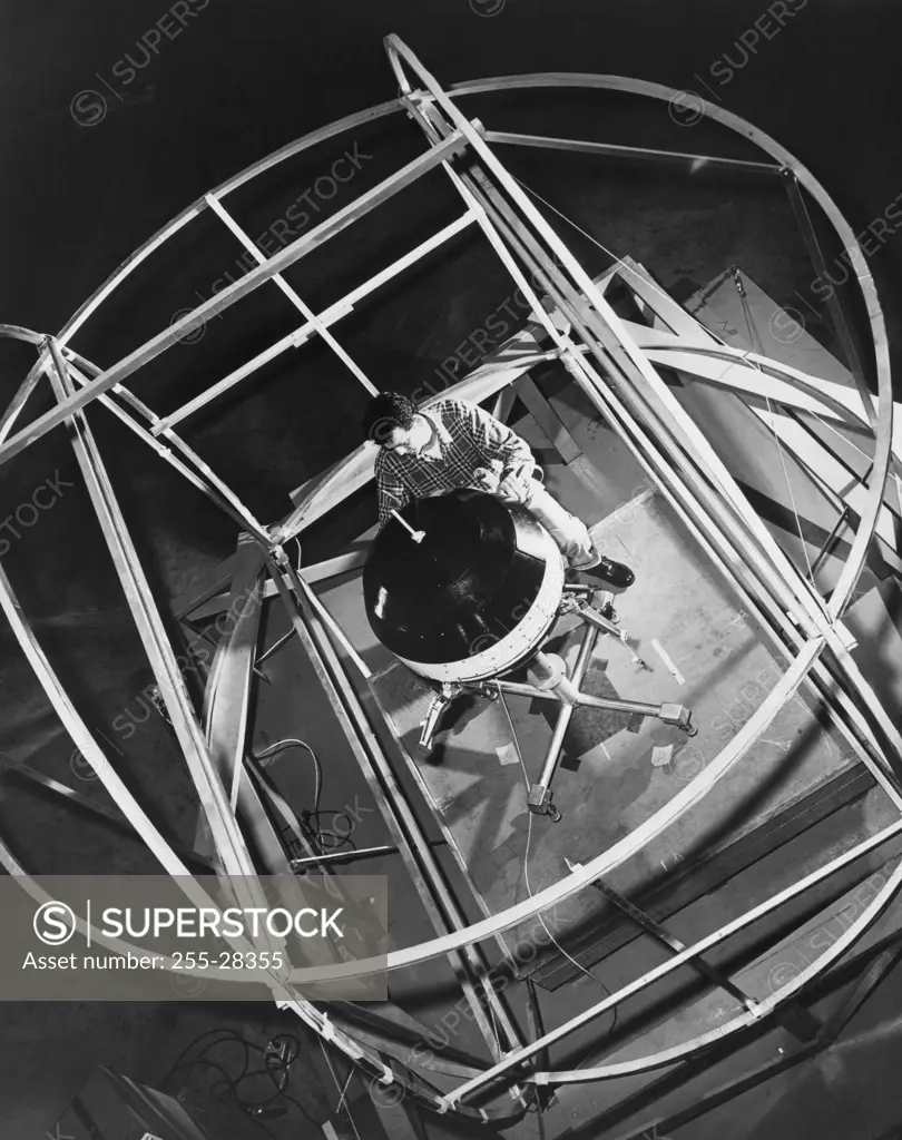 High angle view of a scientist working on a space probe in a laboratory, Pioneer V, Cape Canaveral, Florida, USA