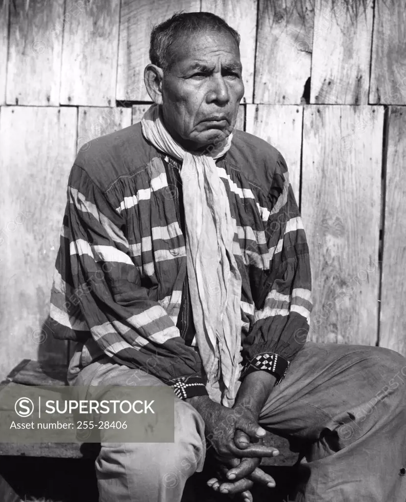 Seminole man sitting with his hands clasped, 1970s