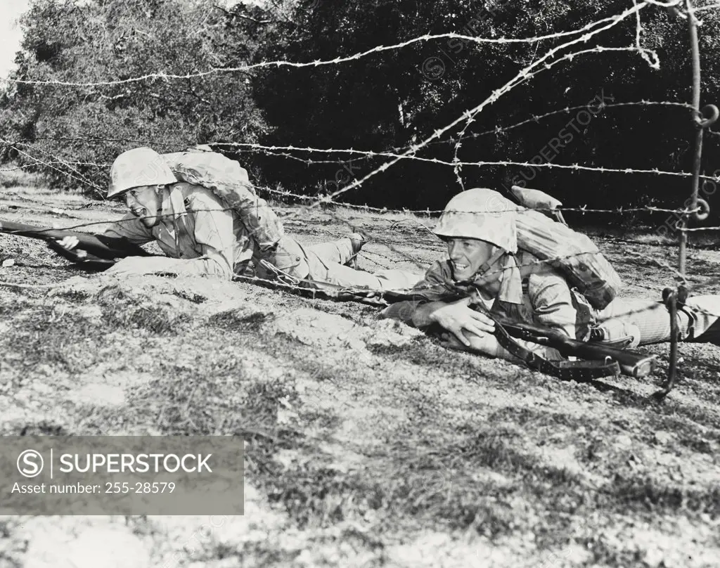 Vintage photograph. Marines crawling under barbed wire with full battle gear on Camp Pendleton combat course