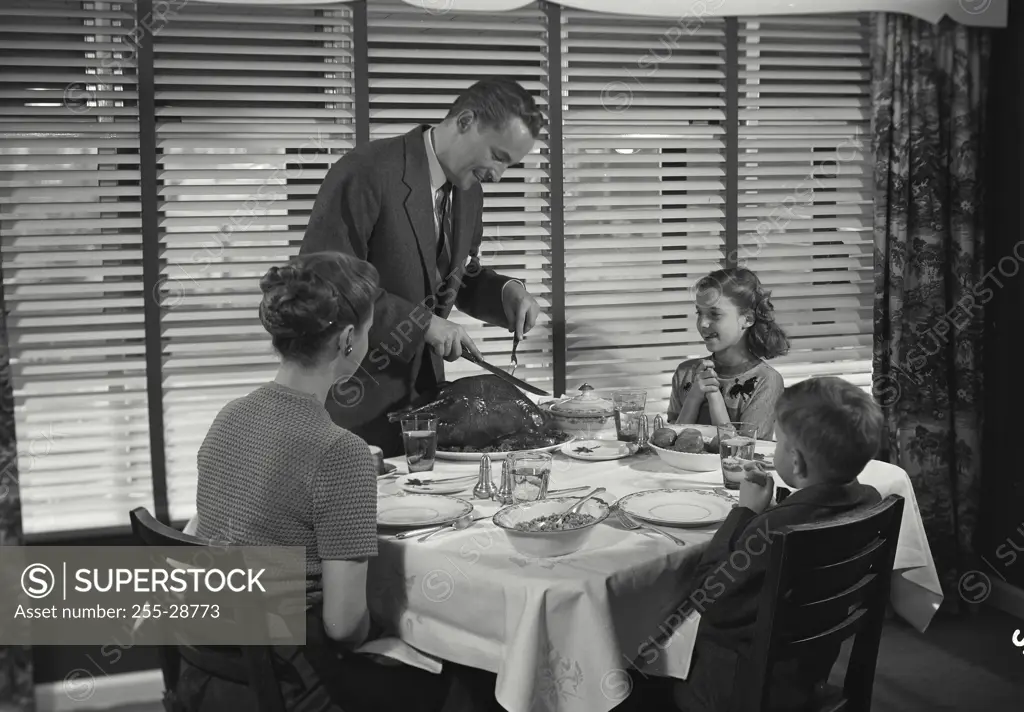 Vintage Photograph. Family at table having dinner together. Frame 1