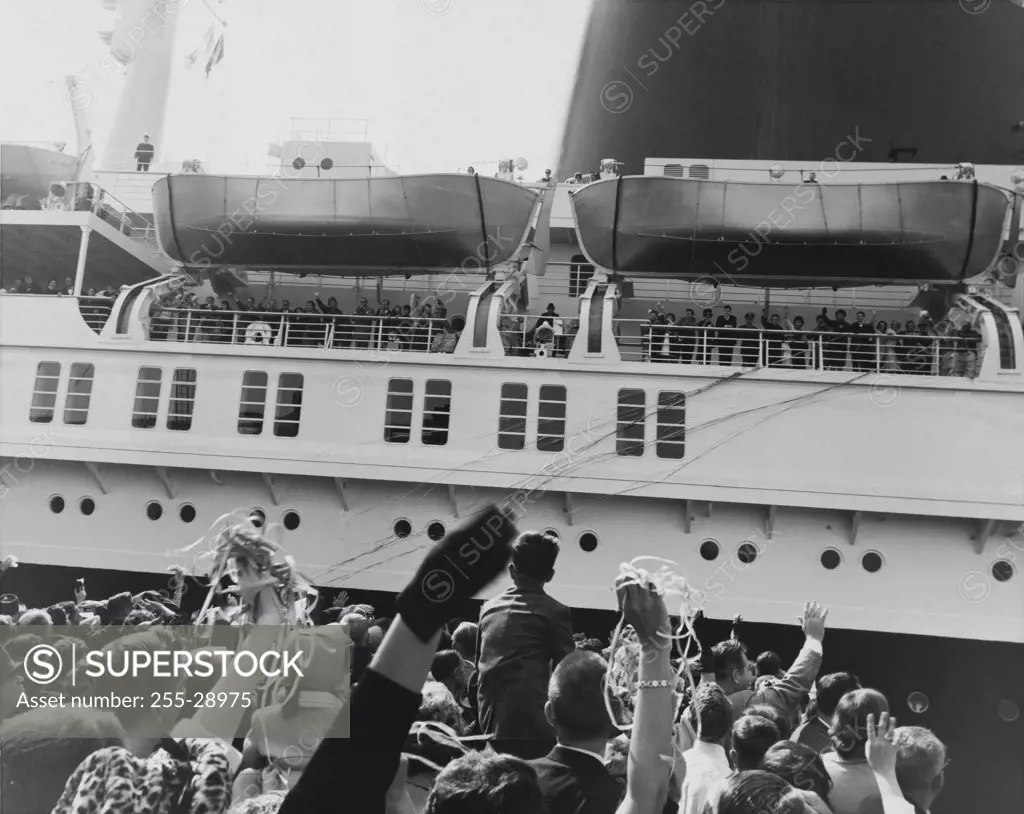 Group of people waving at a departing cruise ship