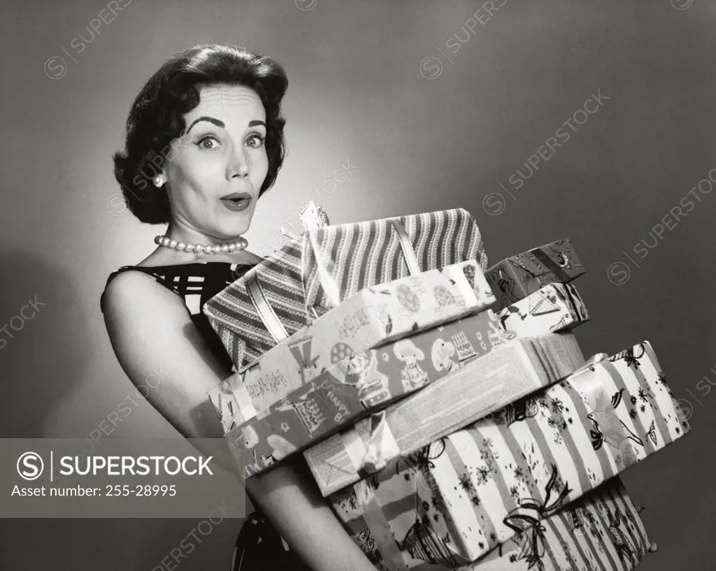 Close-up of a mid adult woman carrying a stack of gifts