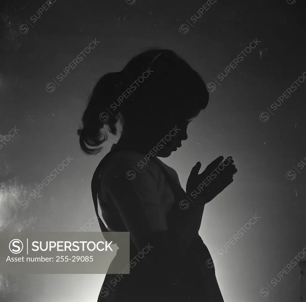 Vintage Photograph. Silhouette of a girl praying