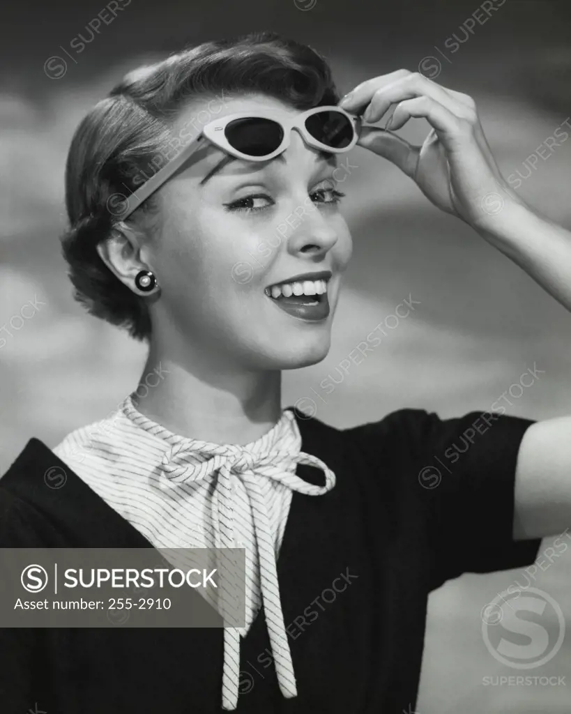 Close-up of young woman holding sunglasses