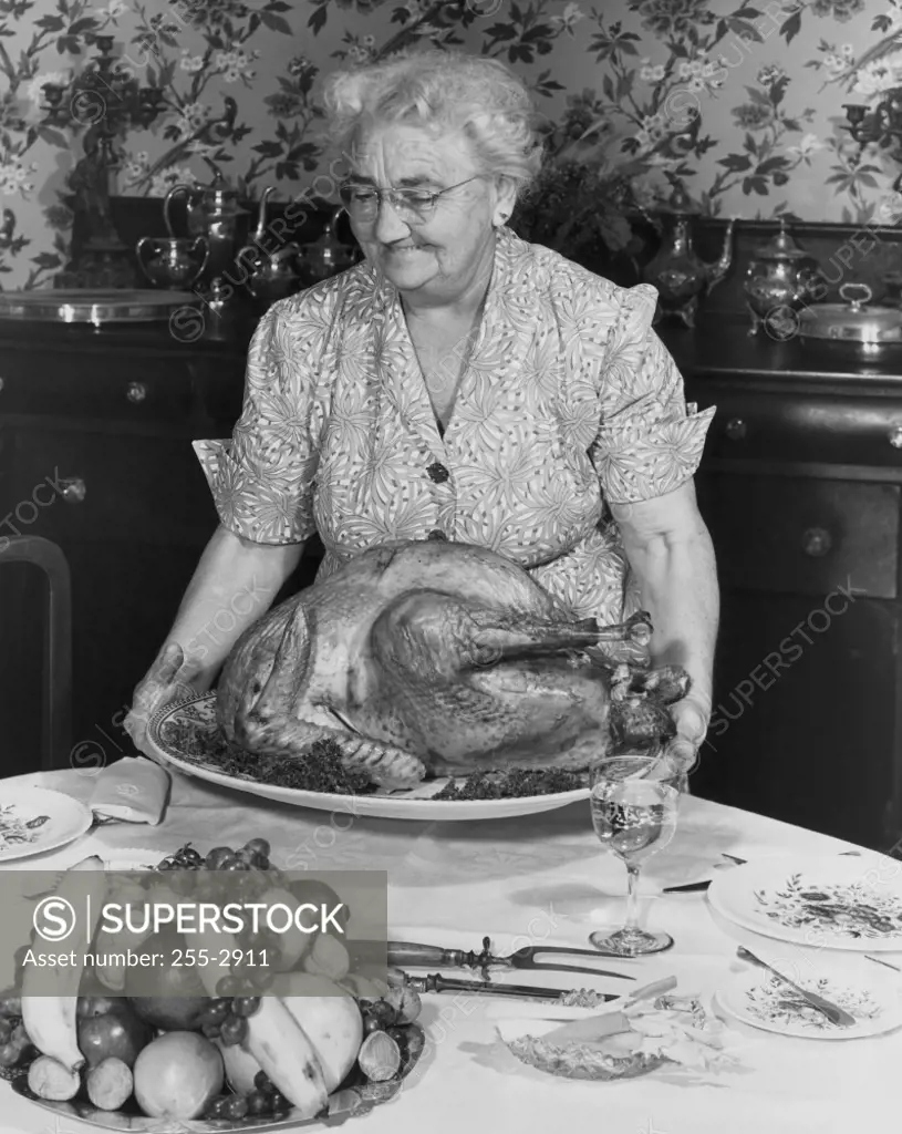 Senior woman holding a roasted turkey