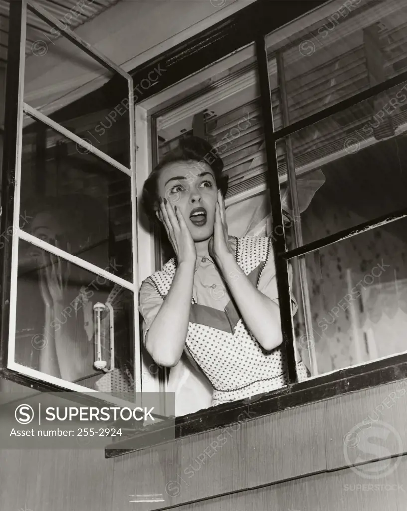 Mid adult woman looking through a window
