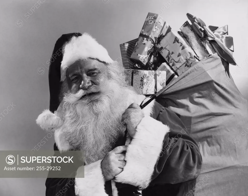 Close-up of Santa Claus carrying a sack of Christmas gifts on his back
