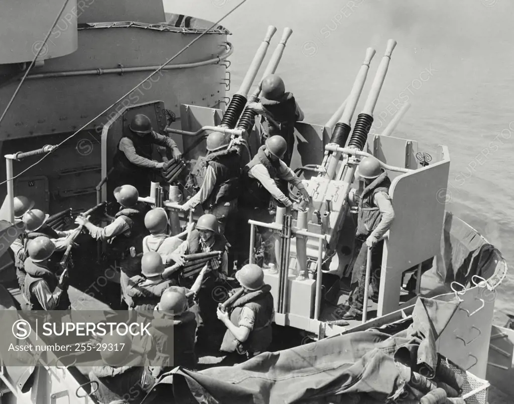 Vintage photograph. High angle view of army soldiers shooting anti-aircraft guns on the coast, USS New Jersey (BB-62), Korea, Sept.1951