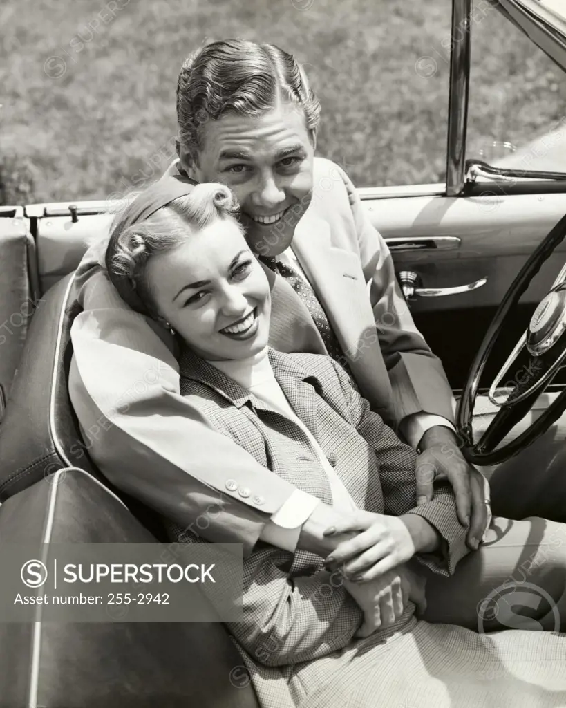 Portrait of a young couple sitting in a convertible car