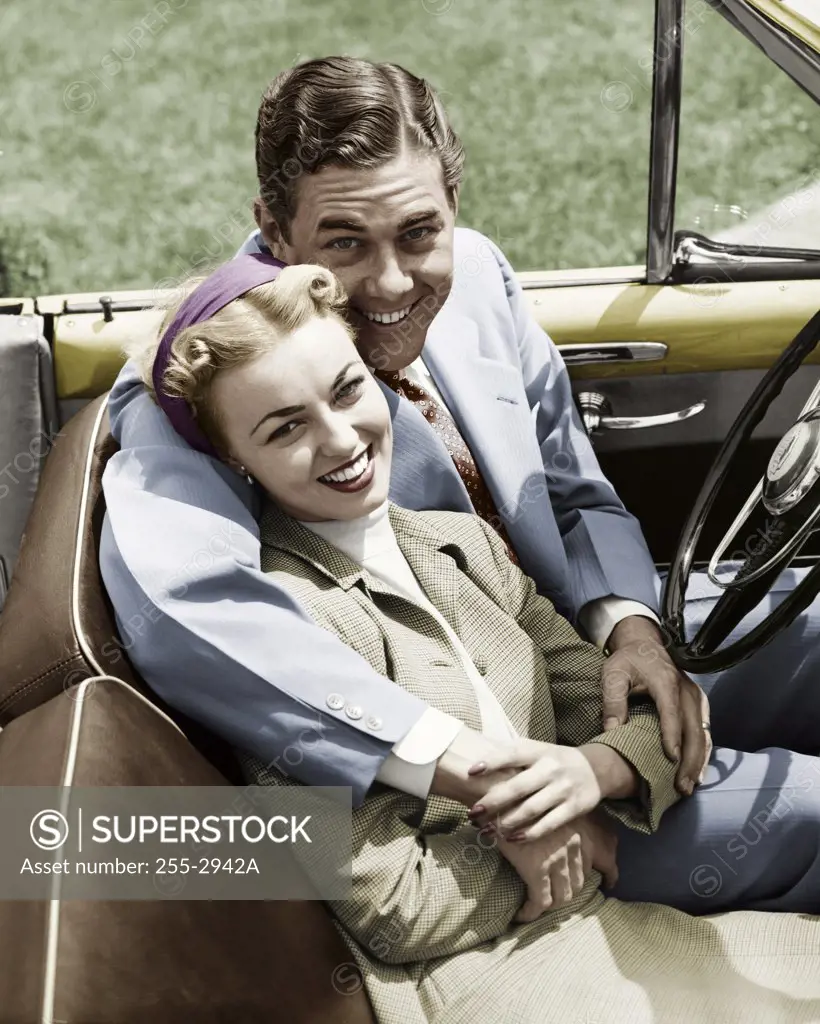 Portrait of young couple sitting in convertible car