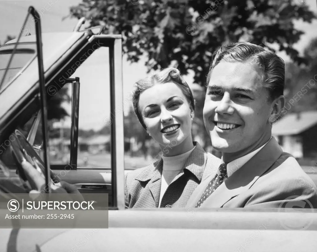 Close-up of young couple sitting in convertible car
