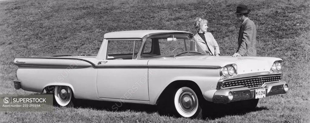 Man and a woman standing near a 1959 Ford Ranchero