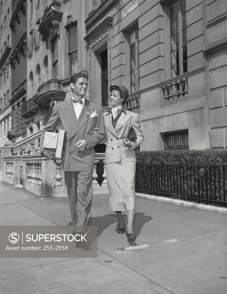 Vintage photograph. Man and wife walking down street with arms locked