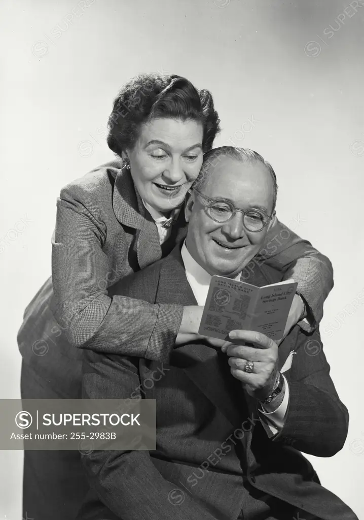 Vintage Photograph. Middle age couple looking at bank book. Frame 1